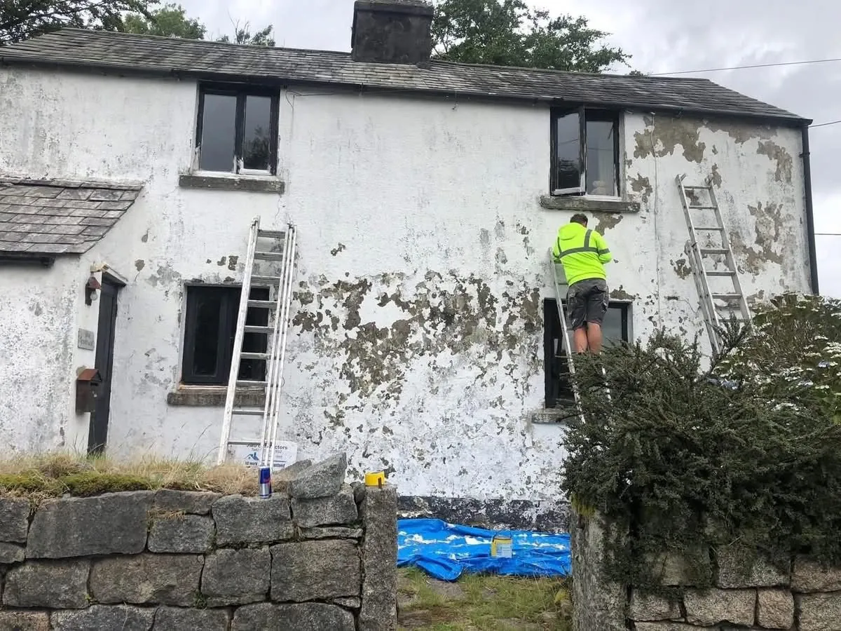 Cottage with blown, flaking render before repair in Dawlish